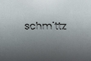 Logo von Schmittz auf einer grauen, strukturierten Oberfläche, das modernes Design und Markenidentität verkörpert.