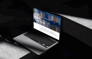 Laptop auf einer dunklen Oberfläche mit einer Webseite, die das Thema Bewegung und Innovation präsentiert.