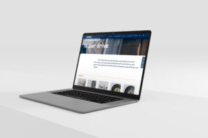 Laptop mit offenem Bildschirm, der eine moderne Website für Reifen und Fahrzeugzubehör zeigt. Der Hintergrund ist neutral und hebt das Gerät hervor.