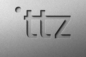 Logo von ITZ auf einer metallischen Oberfläche mit eingravierten Buchstaben.