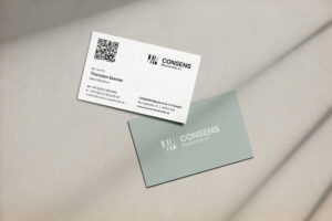 Visitenkarten mit QR-Code und modernem Design, eine weiße Karte mit Kontaktdaten und eine mintgrüne Karte mit Firmenlogo. Ideal für Networking und Geschäftskommunikation.