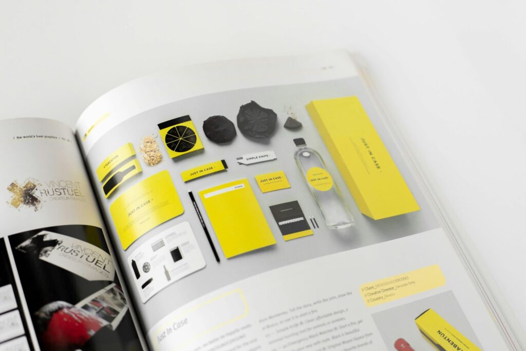 Designbeispiel für Branding und Verpackung mit gelben Elementen von Vincent Rustuel, einschließlich Etiketten, Notizbüchern, einer Flasche und verschiedenen grafischen Materialien auf einer hellen Oberfläche.