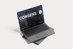 Laptop mit offener Anzeige der Website "CONSENS" für Bautechnik 2.0, auf einem grauen Hintergrund, zeigt moderne Architektur.