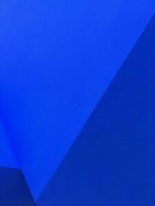 Abstrakte blaue Wand mit geometrischen Formen und Texturen, die ein modernes und minimalistisches Design vermitteln. Ideal für Kunst- und Architekturprojekte.